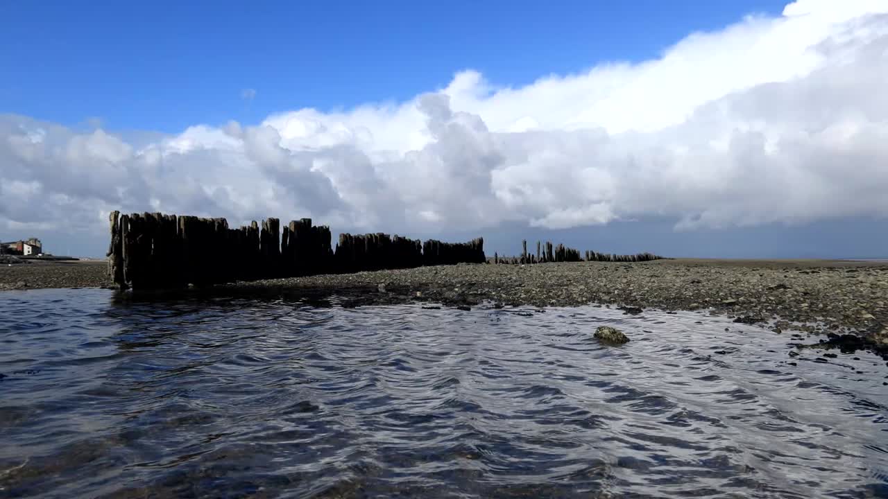 Morecambe Bay shingle pool with blue sky