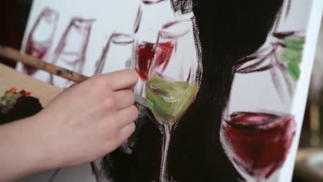 Close-up-of-female-hand-painting-on-white-canvas-glass-of-wine-and-champagne