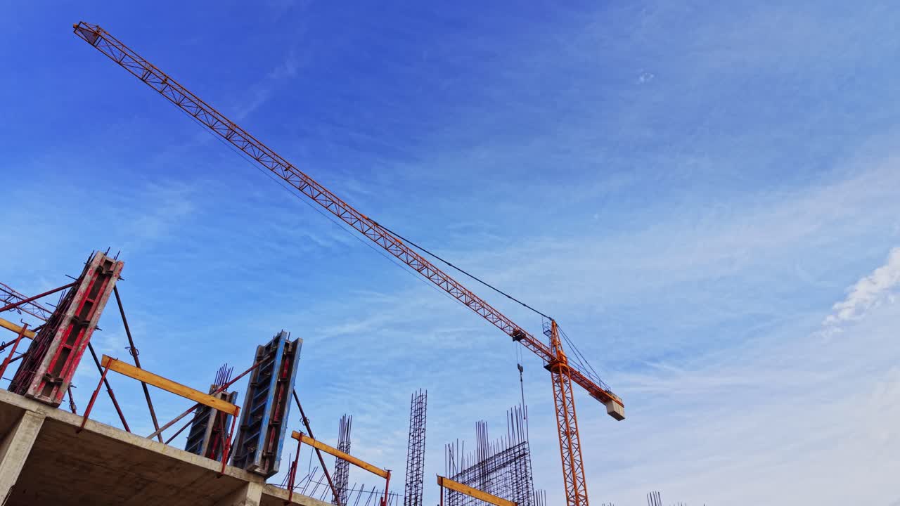 Construction site with crane and rebar against blue sky