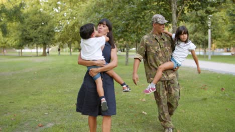 militar feliz caminando en el parque con su familia