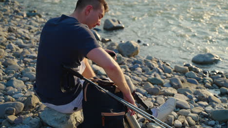 man with prosthetic leg enjoying a drink by the river