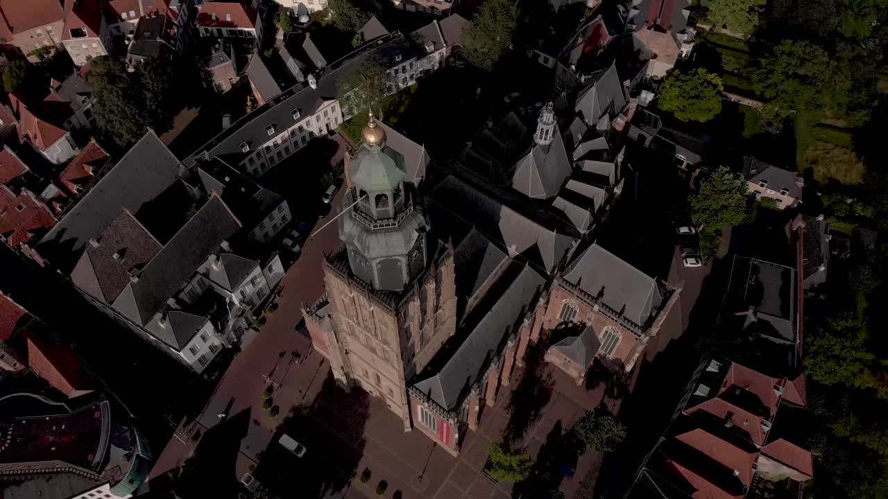 vista lateral de arriba hacia abajo y rotación que muestra la antena de la catedral de walburgiskerk en la ciudad hanseática medieval de zutphen en los países bajos en su entorno urbano al atardecer