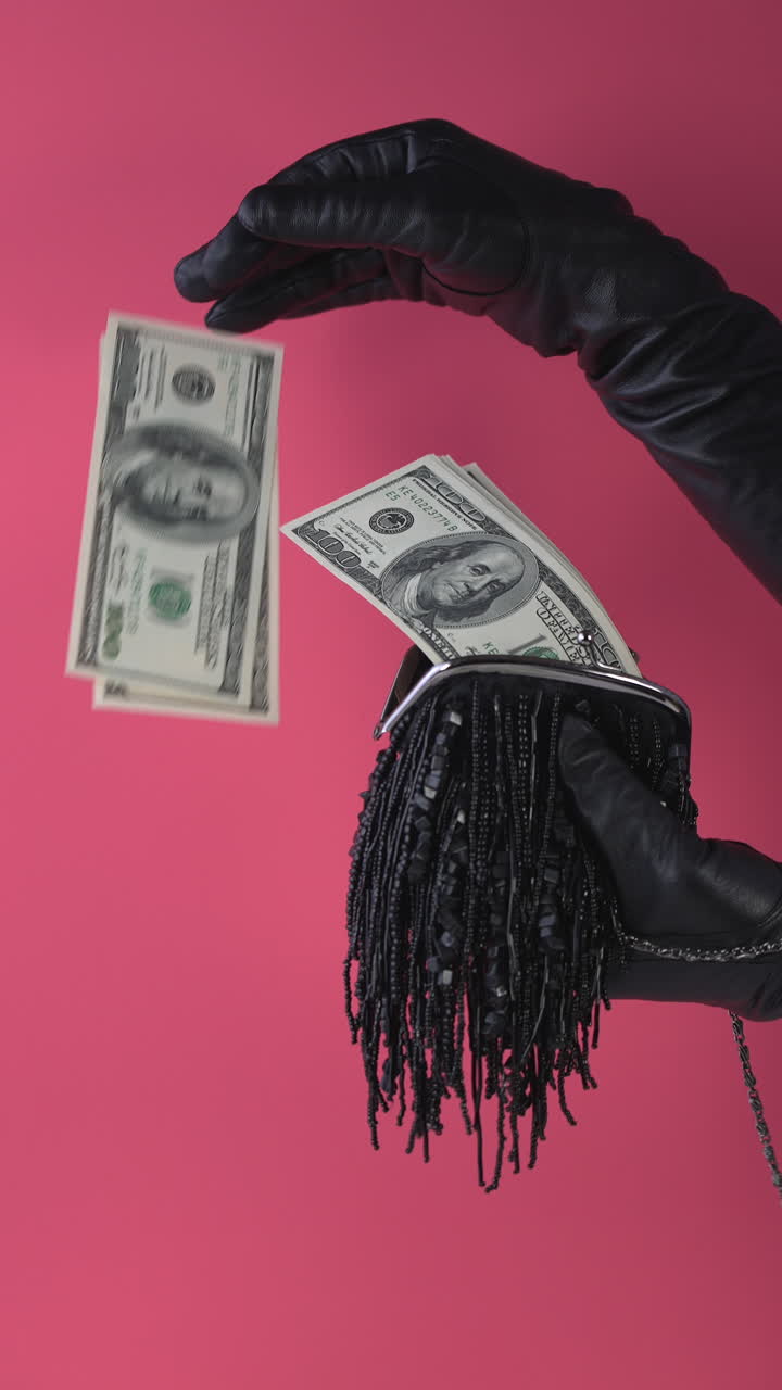 Gloved Hands Taking and Putting Hundred Dollar Bills into a Purse
