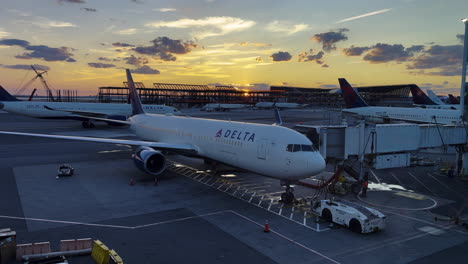 delta airplanes at an airport tarmac during sunset