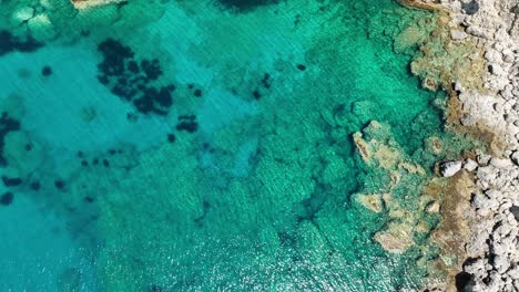 The-stunning-blue-waters-along-corfu-island's-coastline,-sunny-day,-aerial-view