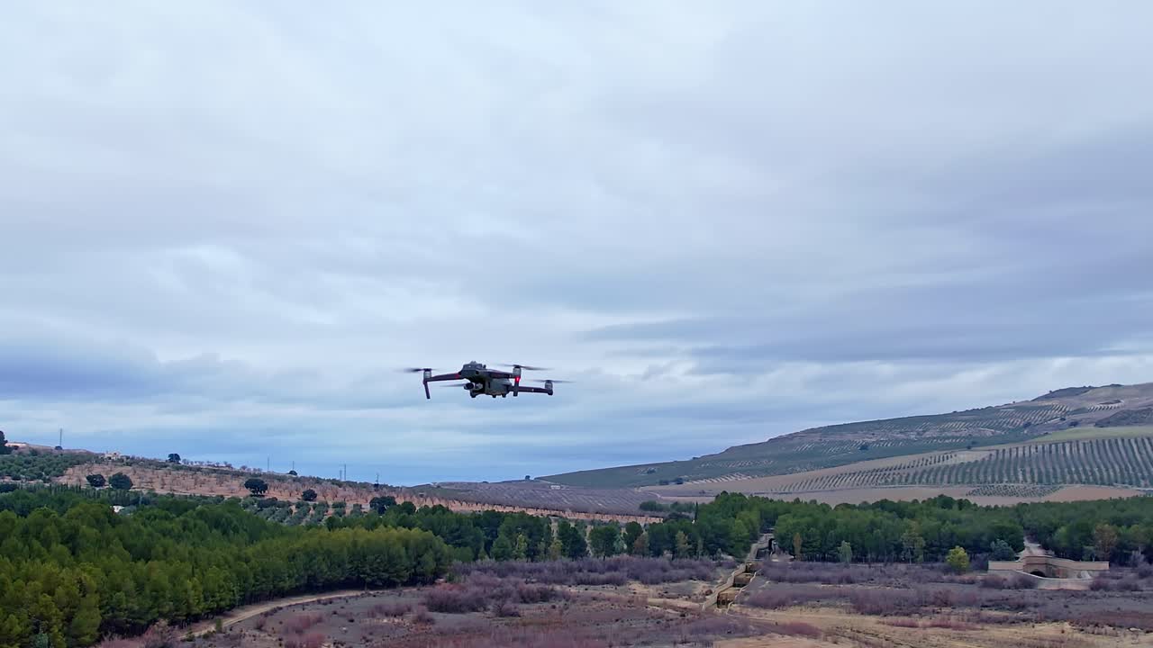 Drone in flight with position lights and signal flashes. Close aerial view.