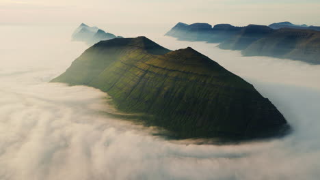 Majestic Green Mountains Emerging from a Sea of Clouds