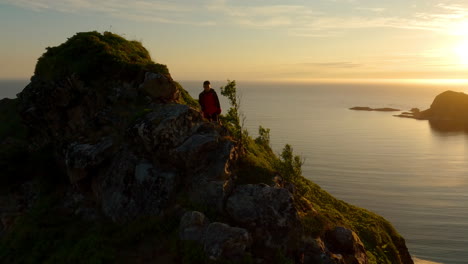 man hiking relaxed on top of mountain with background sun and sea