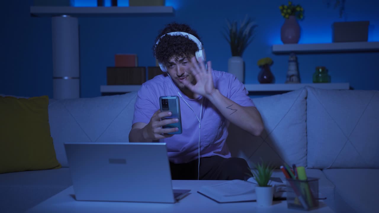 un joven chateando en video con su novia por la noche.