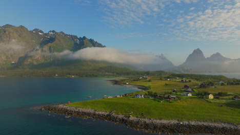 norwegian village with flying eurasian oystercatcher bird in holdoya in the lofoten islands, norway