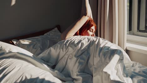 woman stretching in bed at sunrise