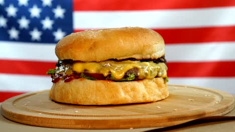 fresh juicy burger is fast rotating on us flag background.