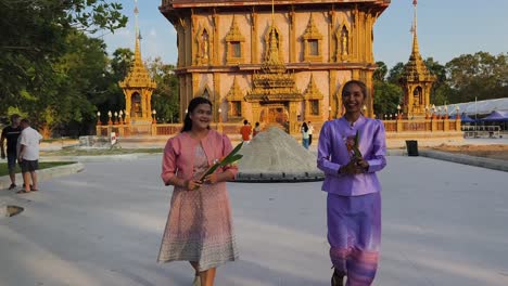 women in traditional thai clothing at a temple ceremony