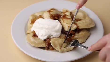 pierogi con crema agria y cebollas