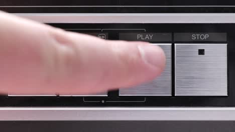 extreme close up of buttons on an old antique or vintage vcr a finger coming in and pushing play