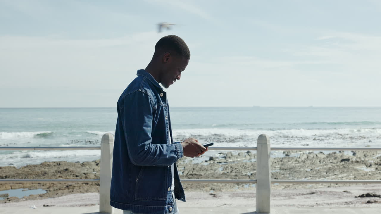Man using phone by the beach