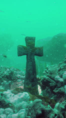 underwater cross: a submerged stone cross in a coral reef