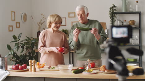 senior couple filming culinary vlog together