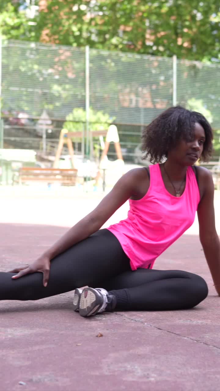 Donna che fa stretching su un campo sportivo all'aperto