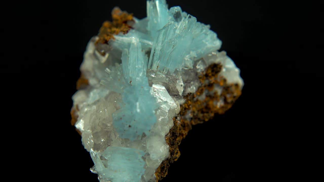 검은색 배경 앞에 밝은 파란색 미네랄 (바리트) 을 원활하게 회전시니다.