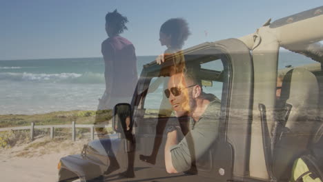 leaning on car window, man watching people walking on beach by ocean