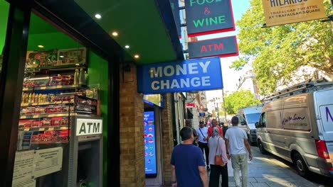 pedestrians walk past a money exchange in london