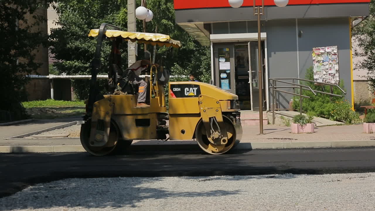 Laying Asphalt On The Street. VINNITSA, UKRAINE - JULY 2017: Steamroller during the asphalt laying on the road construction site