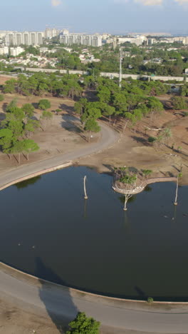 close-up on a lake of calm hippos in the afternoon above ramat gan safari when it is empty of visitors. main transport road in the background - paralax - vertical video