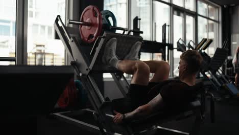 man working out on leg press machine in gym