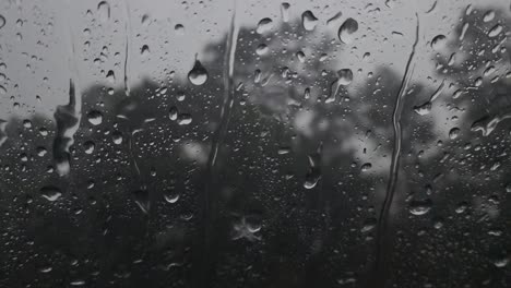 Este-Es-Un-Video-De-Grandes-Gotas-De-Lluvia-Que-Caen-Sobre-La-Ventana,-Provocando-Que-Se-Formen-Pequeños-Arroyos-Que-Ruedan-Por-La-Ventana.