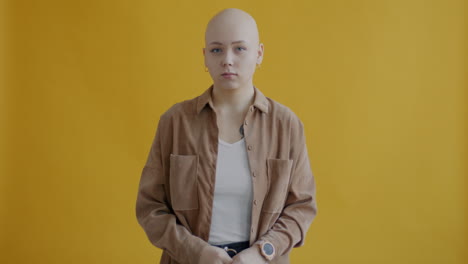 woman with serious expression in front of yellow background
