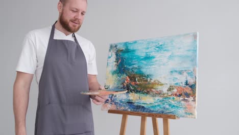 the talented artist shows the created abstract picture - the talented artist shows the created abstract picture. joyful artist shows thumb up