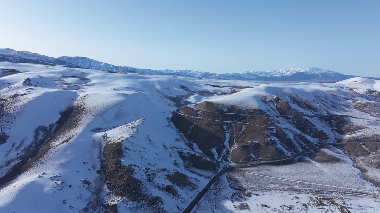 Droneoptagelse fra høj højde af sneklædte bakker i Mono Lake, Californien.