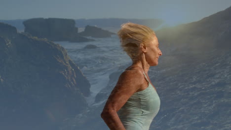 composite of senior caucasian woman running, with sunset over cliffs and sea