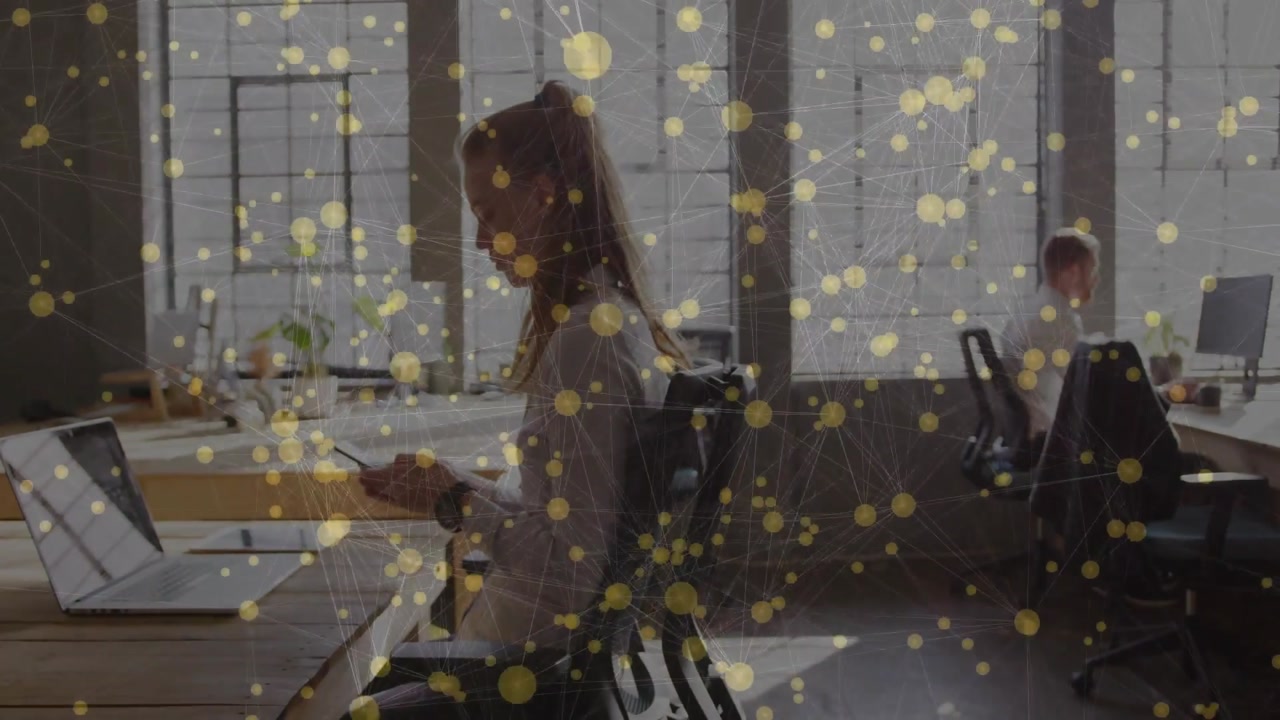 Vertical video: Woman tapping phone at PC in business, causing gold dots to shift as camera panning