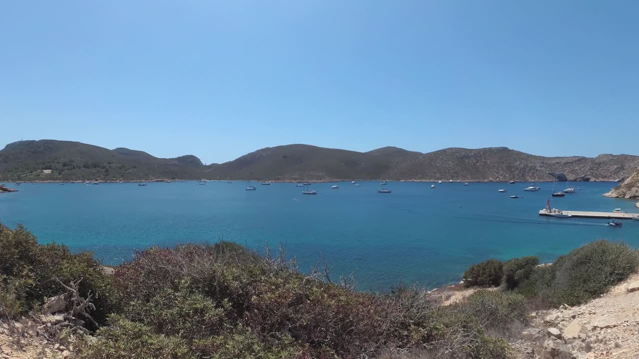 Stunning Coastal View with Boats and a Person Walking on a Path