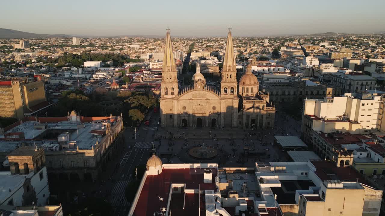 Drone se aproximando da catedral de Guadalajara, Jalisco, México, paisagem urbana de capital ao pôr do sol, filmagem aérea