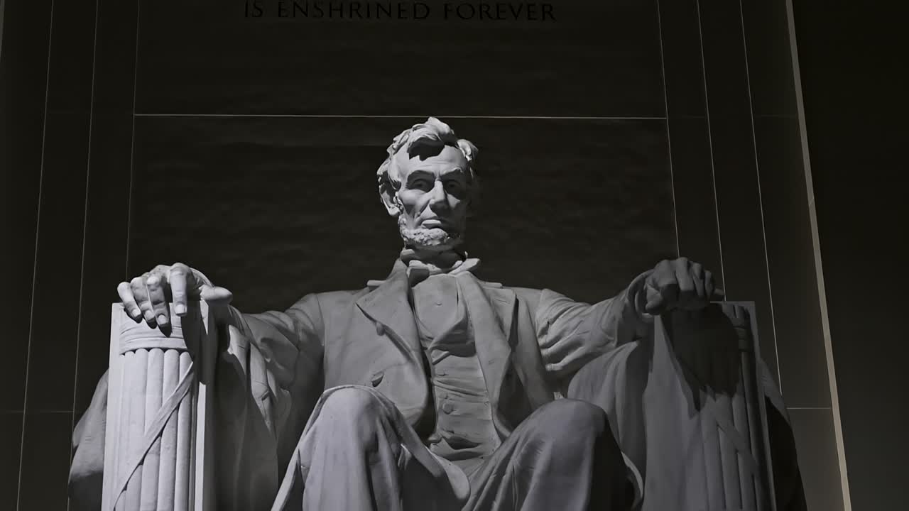 A tilt reveal of the Lincoln Memorial lit at night from a low angle.