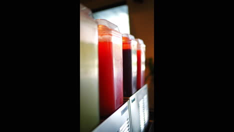 metal rack displaying colorful juice dispensers with diverse beverages, presenting enticing beverage selection for restaurant or cafe customers