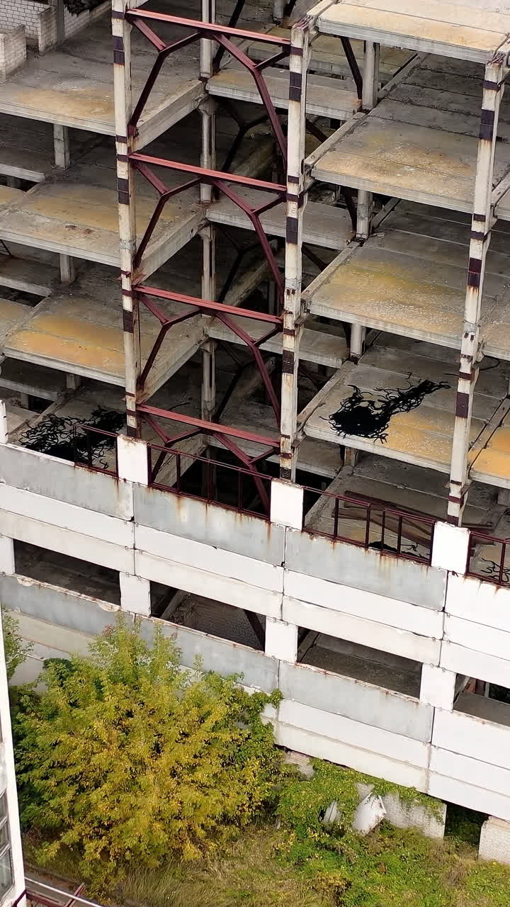 Empty destroyed factory buildings on the background. Aerial view of old abandoned factory. Vertical video