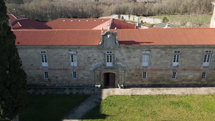 Ingresso del monastero e cortile con croce e albero alto di San Salvador de Ferreira