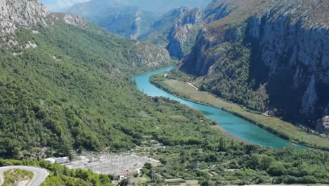 River-in-coastal-Croatia,-Cetina,-meandering-between-rocky-hills-and-entering-Adriatic-Sea-in-Omis,-an-aerial-view