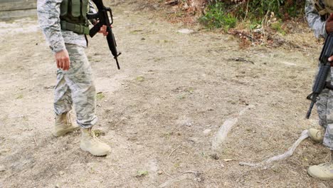 soldado que lleva a un soldado herido durante un ejercicio de entrenamiento con un arma