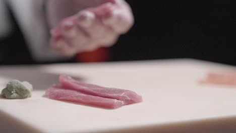 a static shot of a chef adding wasabi to tuna in preparation for sushi. perfect for showcasing sushi making techniques, ingredient preparation, and japanese culinary skills in action.