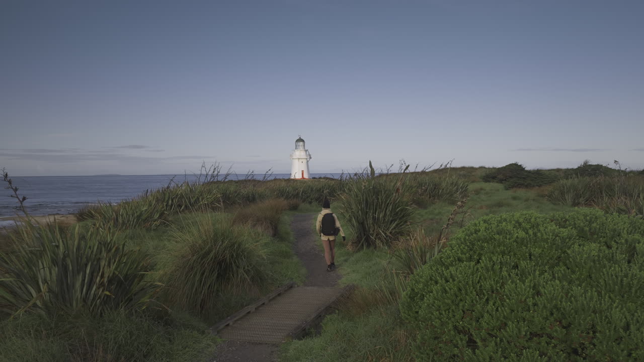 와이파파 등대를 향해 해안 길을 따라가는 여성 배낭 여행자