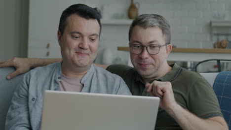 dos hombres viendo algo en una computadora portátil
