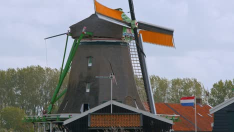 Molino-De-Viento-De-Madera-Giratorio-Con-Bandera-Holandesa-Cerca-De-Amsterdam,-Inglaterra