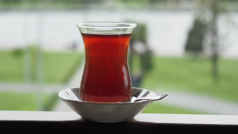 un vaso de té turco en un balcón con vistas a un parque