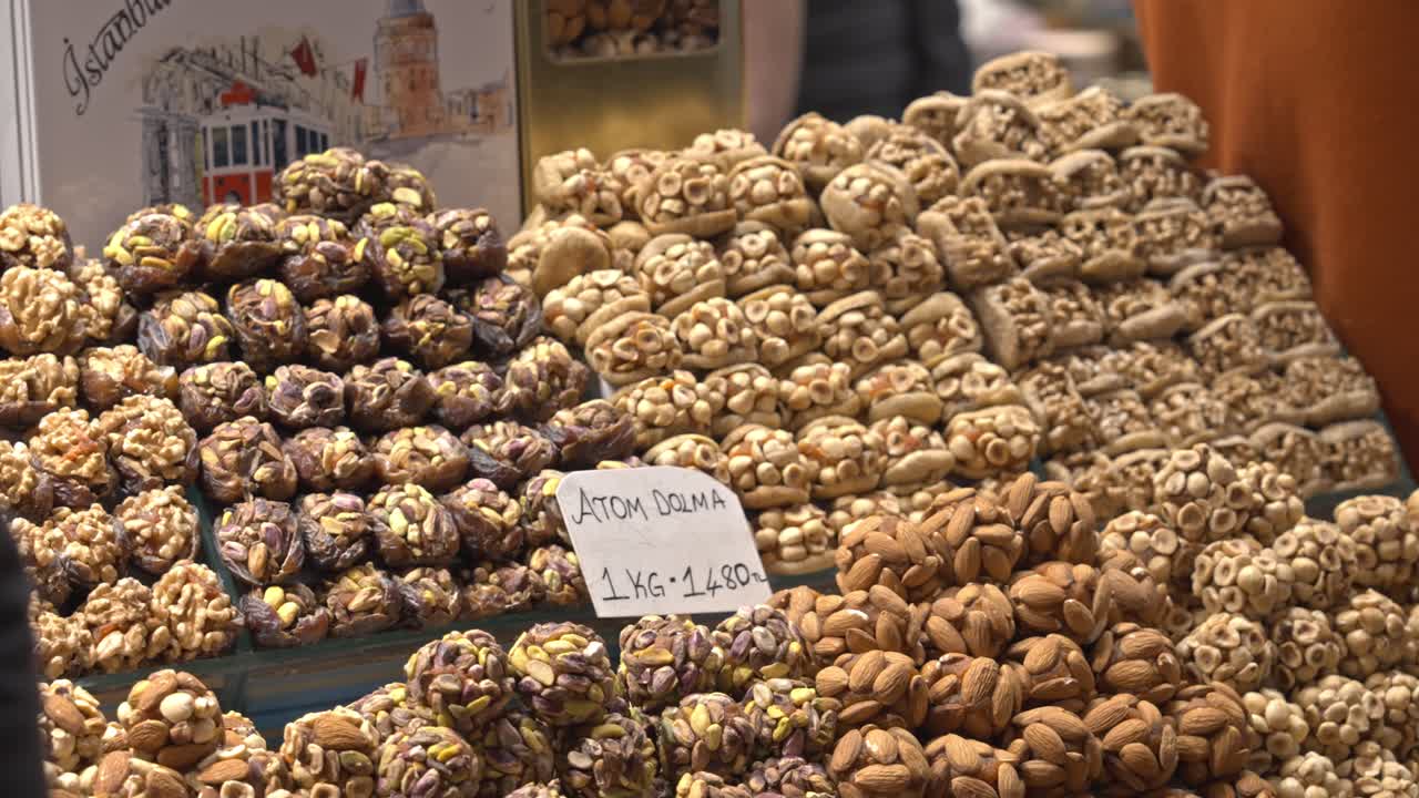 A vibrant display of various traditional Turkish delights (Lokum) and colorful candies arranged behind a glass counter in the historic Mısır Çarşısı (Spice Bazaar) in Istanbul, Turkey