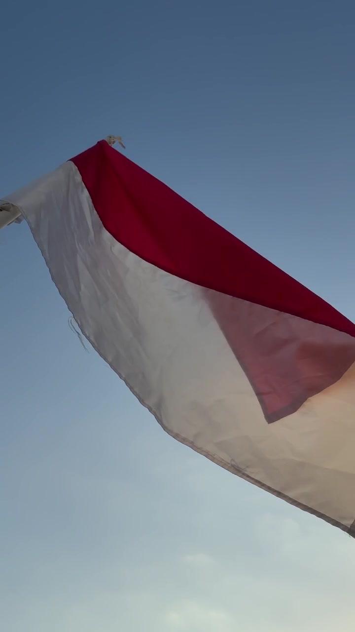 Bandeira da Indonésia Ondeando Contra um Céu Azul Claro